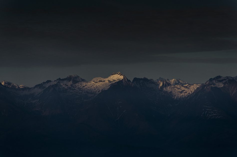 sunlight-shining-single-mountain-top-sunset-with-dark-cloudy-sky